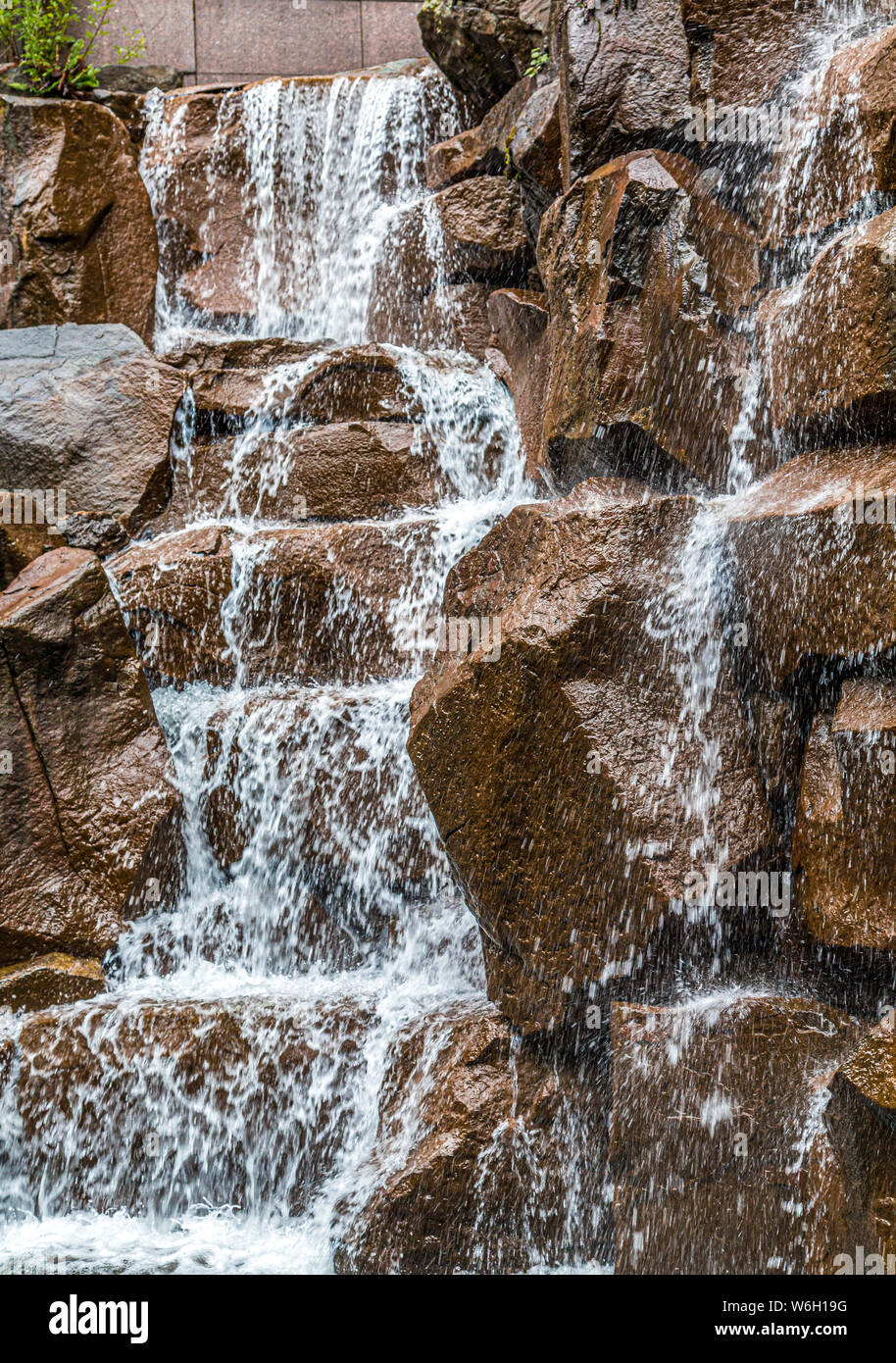 Garten im Wasserfall über braune Steine Stockfoto