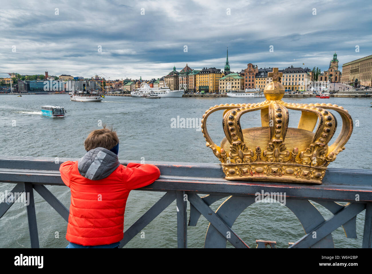 Ansicht der Rückseite des Kindes auf Brücke Skeppsholmsbron (Skeppsholm) neben dem legendären goldenen Krone, Stockholm, Schweden Stockfoto