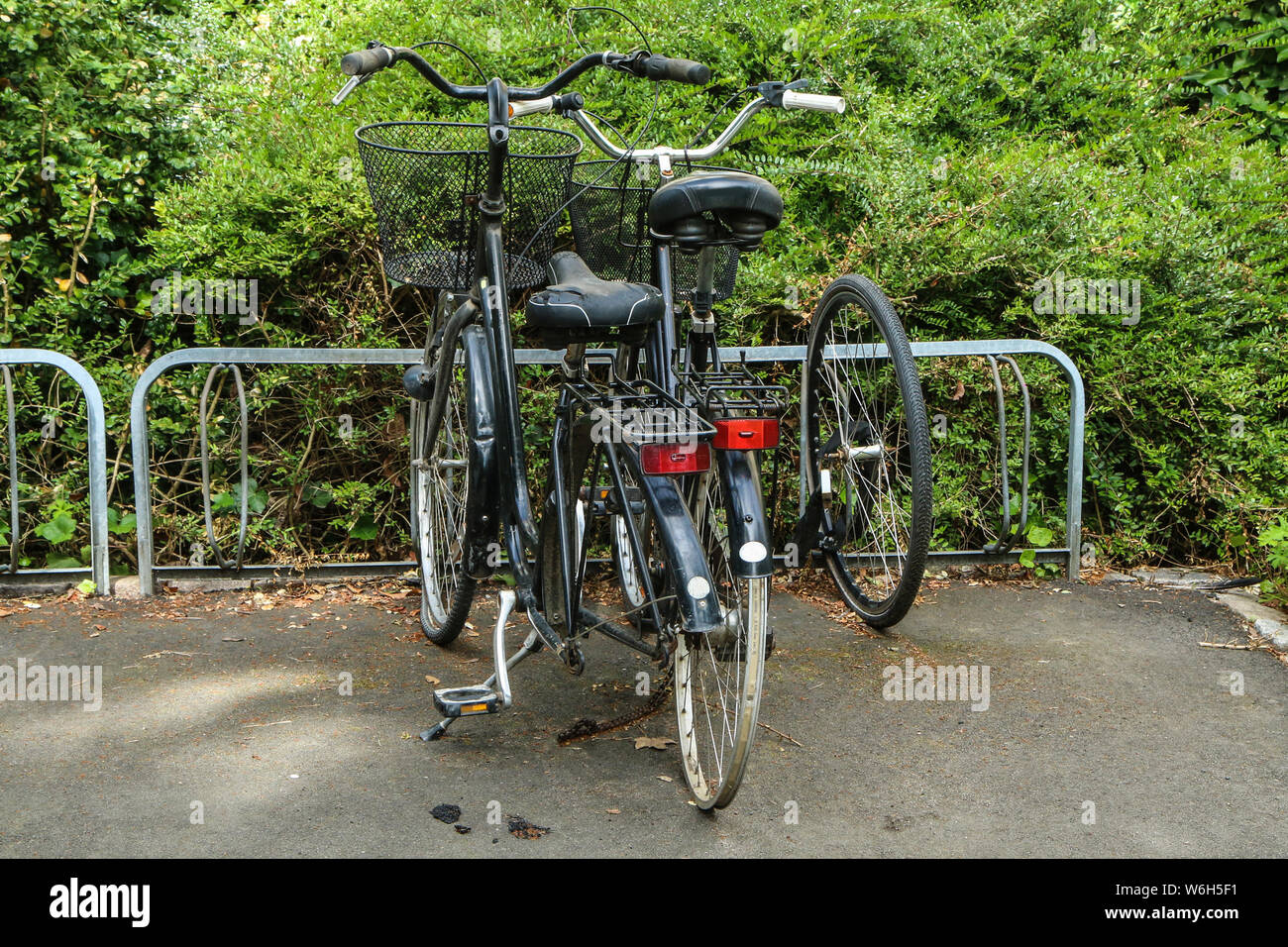 Mehrere beschädigte und zerstörte Fahrräder stehen auf einer Straße in einem Ständer mit fehlenden Teilen. Die Diebstähle gestohlen hat einige Teile und die Fahrräder sind jetzt aufgeben Stockfoto