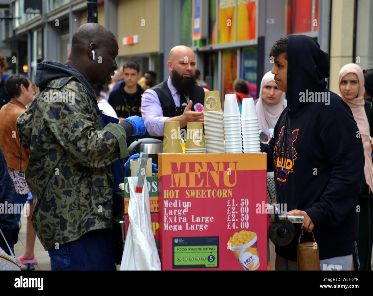 Ein Verkäufer von hot Mais von einem mobilen Warenkorb auf der Market Street, Manchester, UK Stockfoto