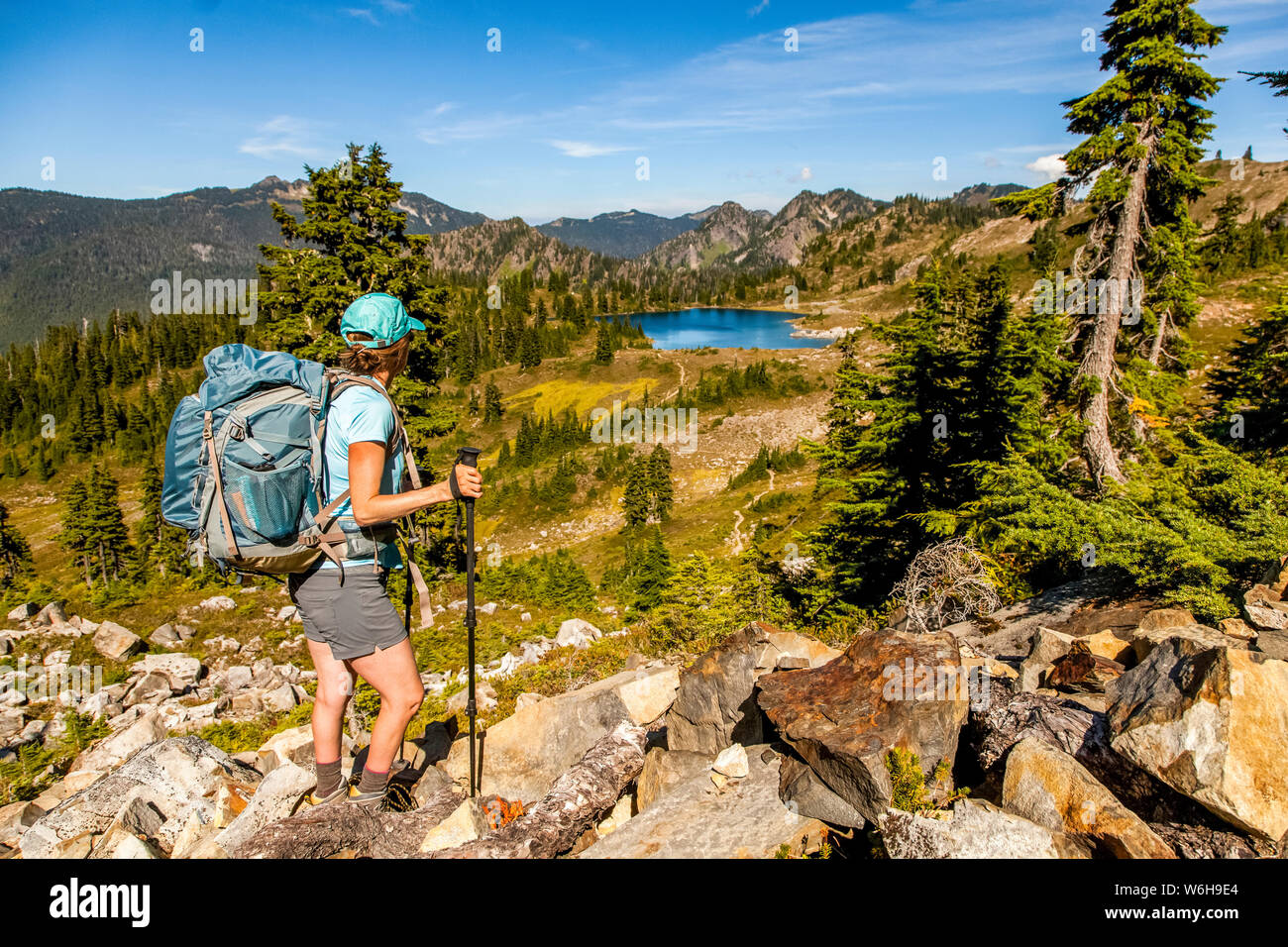 Weibliche Backpacker auf High Divide Trail pausieren, um einen Blick auf den Lunch Lake im Sommer, Seven Lakes Basin, Olympic National Park, Ol... Stockfoto