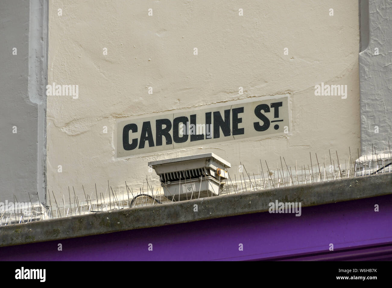 CARDIFF, WALES - Juli 2019: Nahaufnahme der Straßenschild auf ein Gebäude zu Beginn der Caroline Street, gut für Essen in der Nacht in Cardiff bekannt Stockfoto