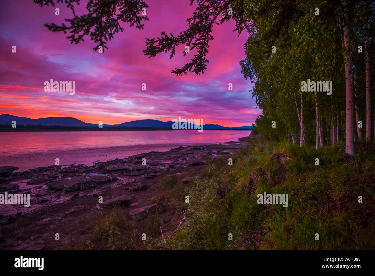 Sonnenuntergang / Sonnenaufgang Anfang Juni auf dem Yukon River im Sommer, Alaska, Vereinigte Staaten von Amerika Stockfoto
