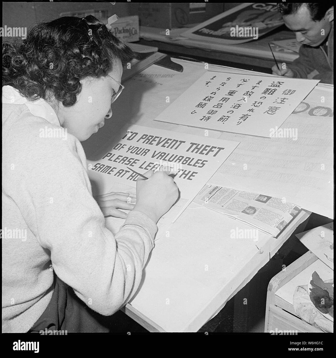 Herz Berg Relocation Center, Heart Mountain, Wyoming. Im Poster Shop im Herzen Berg. . .; Umfang und Inhalt: Der vollständige Titel für dieses Foto liest: Herz Berg Relocation Center, Heart Mountain, Wyoming. Im Poster Shop im Herzen Berg Relocation Center, ein junger Künstler ist der erste Entwurf einer allgemeinen Bekanntmachung. Das Bild zeigt auch die japanische Version des gleichen beachten, die auch für die älteren Menschen, die nicht englischer Sprache gebucht werden. Stockfoto