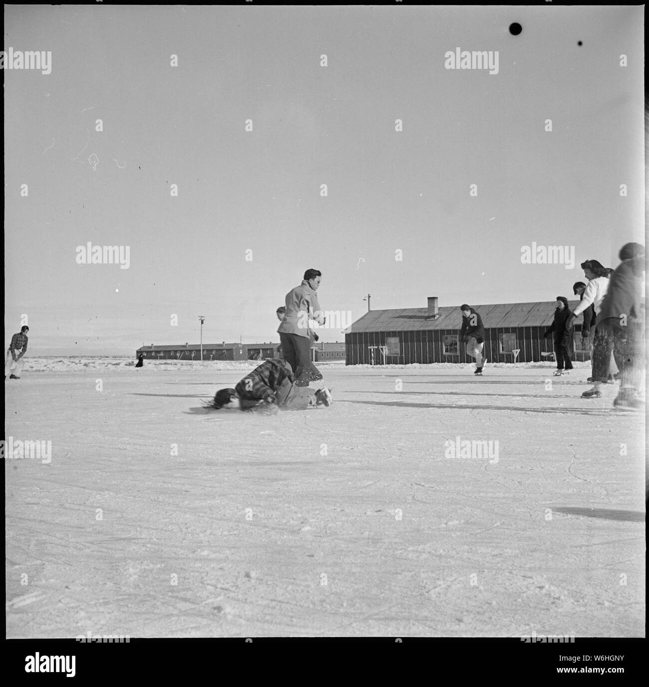 Herz Berg Relocation Center, Heart Mountain, Wyoming. Mit dem Kommen des kalten Wyoming temperat. . .; Umfang und Inhalt: Der vollständige Titel für dieses Foto liest: Herz Berg Relocation Center, Heart Mountain, Wyoming. Mit dem Kommen des kalten Wyoming Temperatur, Eishallen wurden überflutet, und viele ehemalige Kalifornier japanischer Abstammung, der jetzt am Herzen Berg wohnen, hatten ihre ersten Erfahrungen auf Schlittschuhen. Der Knabe auf der linken Seite ist Lernen, trotz gemeinsamer cartoon Merkmale. Ein Kissen auf das Gesicht könnte auch helfen. Stockfoto