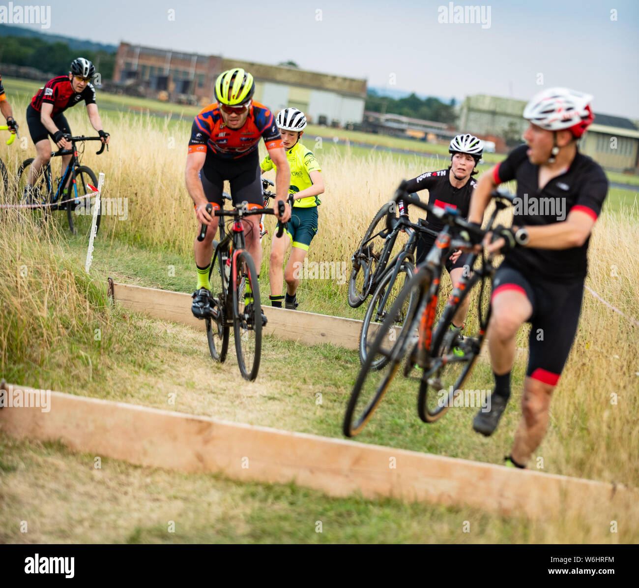 Abingdon, Oxfordshire, UK. 1. August 2019. Boards dazu führen, dass ein wenig Chaos während des Rennens. Nehmen Sie 3 Sommer der CX-Serie. Die cyclocross Veranstaltung in Abingdon Flugplatz Donnerstags zieht Radfahrer im Alter von 6 bis 60 etwas. Cyclocross Bike Racing in gemischten Gelände. Das Wetter war warm und sonnig. Credit: Sidney Bruere/Alamy leben Nachrichten Stockfoto