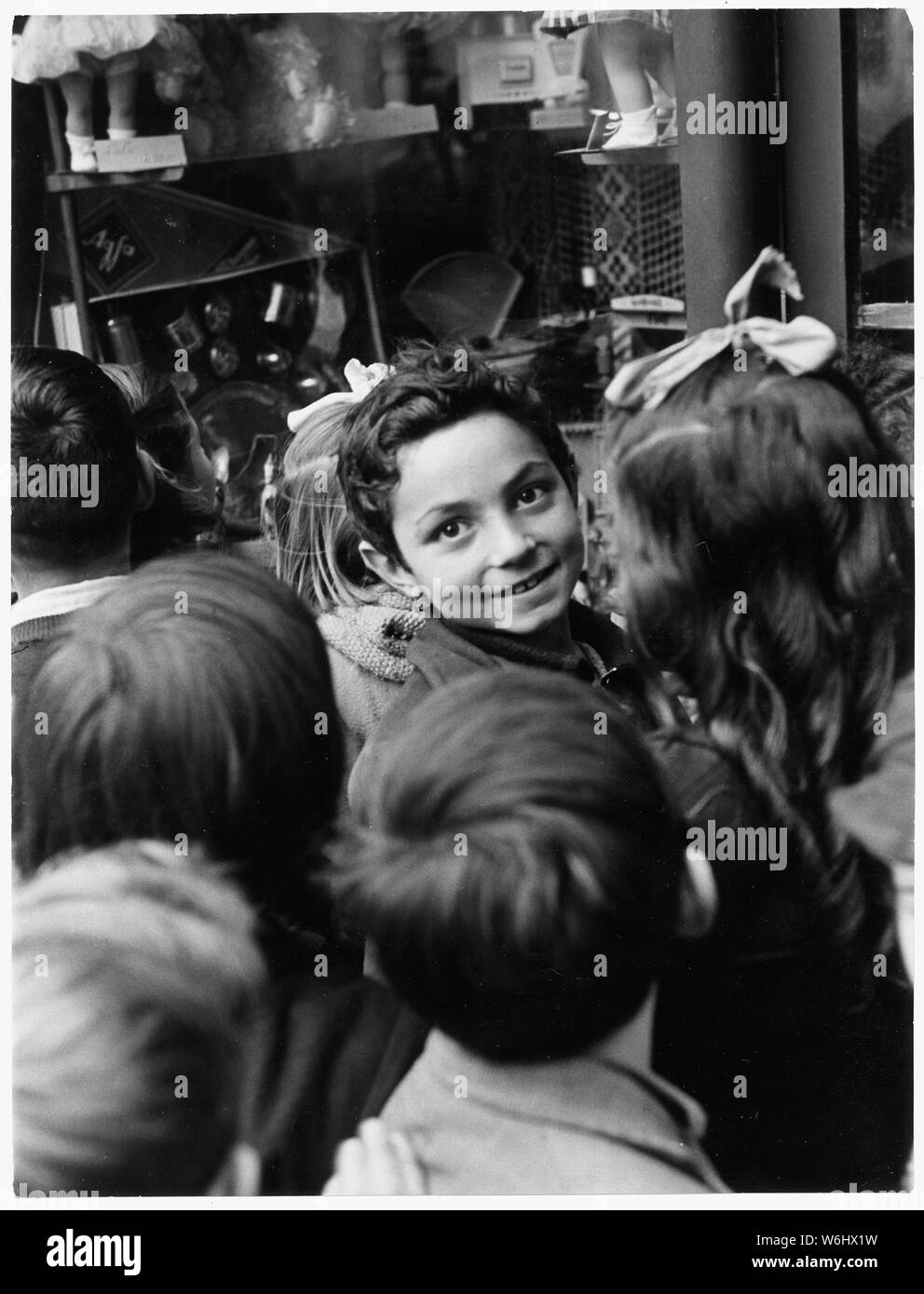 Iglesias, Italien. Entlang der Via Matteoti, Main Street von Iglesias, Kinder stehen vor einem Schaufenster mit Weihnachten Spielzeug wie kleine Kinder überall auf der Welt verzaubert. Obwohl die Bedingungen auf der Insel mit einem 3 Rückgang bei den Kosten für Wohnraum und eine 2 Anstieg der Löhne verbessert haben, im letzten Jahr, sehr wenige Familien haben Geld links die zusätzlichen Luxus Schmuck oder Spielzeug für ihre Kinder kaufen Stockfoto