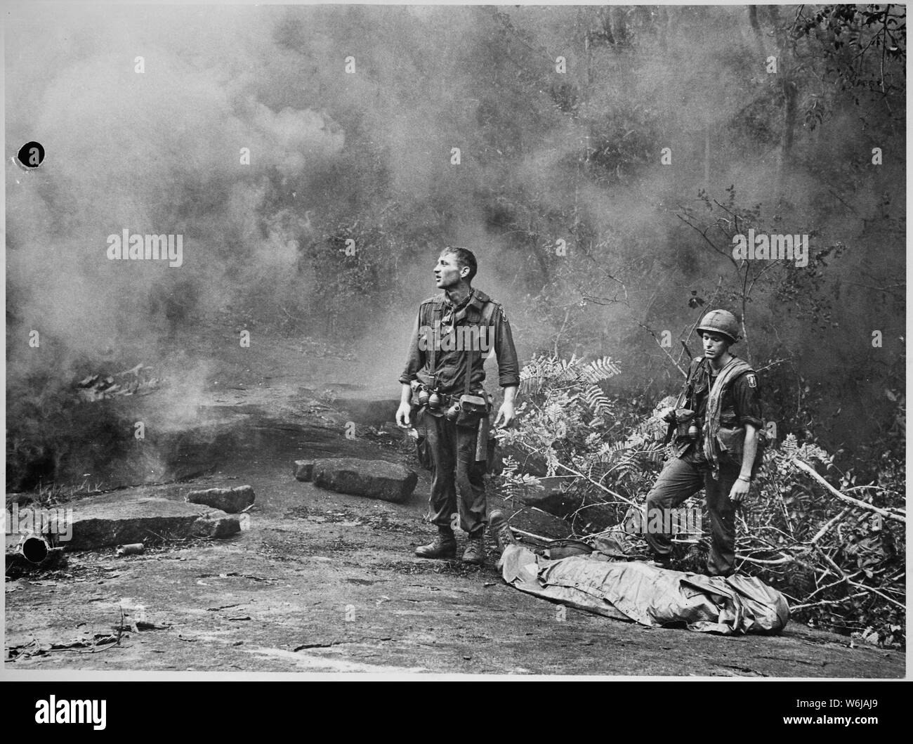 Lange Khanh Provinz, Republik Vietnam... SP4R.Richter, 4.BATAILLON, 503Rd Infanterie, 173Rd Airborne Brigade, hebt seinen Kampf müde Augen in den Himmel, als ob Sie sich fragen, warum? Sergeant Daniel E. Spencer starrt unten an ihren gefallenen Kameraden. Kampf der Tag endete, die schweigend Warten auf die Hubschrauber, die ihre Kameraden aus dem Dschungel evakuieren bedeckten Hügeln. Stockfoto