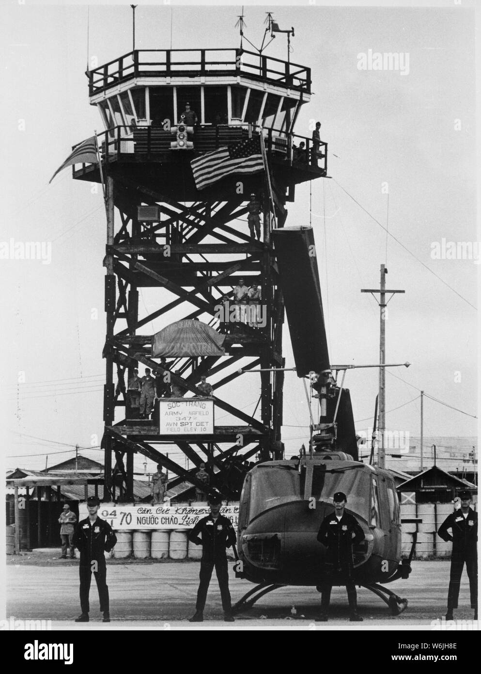 Momente, bevor die US-Flagge von der Vietnamesischen Flagge ersetzt wurde, Vietnamesischen Luftwaffe Besatzungsmitglieder Line up vor einem der 62 UH-1 Huey Hubschrauber über ihnen November 4, 1970 gedreht, zusammen mit der Soc Trang Flugplatz., 1958 - 1974; Allgemeine Hinweise: Verwenden Sie Krieg und Konflikt Nummer 401 bei der Bestellung eine Reproduktion oder Anforderung von Informationen zu diesem Bild. Stockfoto