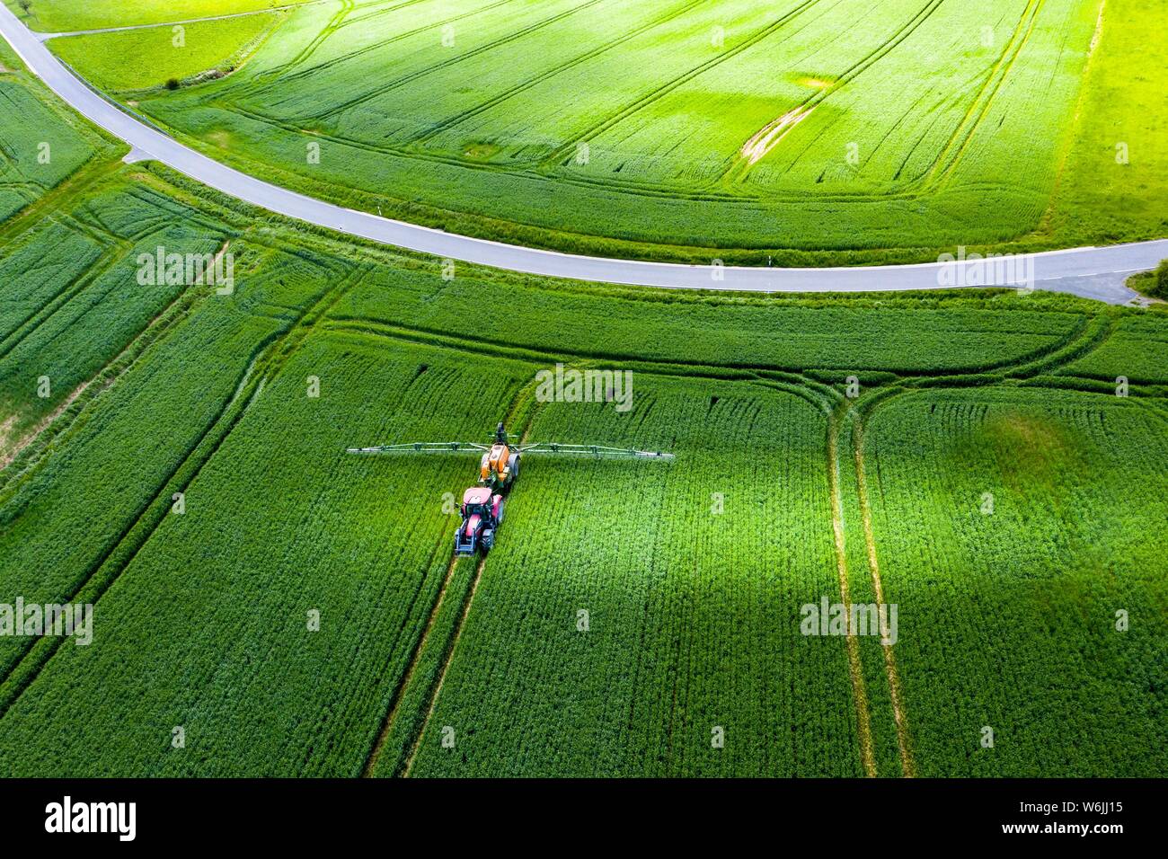 Luftaufnahme, Traktor Spritzen ein Feld mit Düngemitteln, Wetterau, Hessen, Deutschland Stockfoto