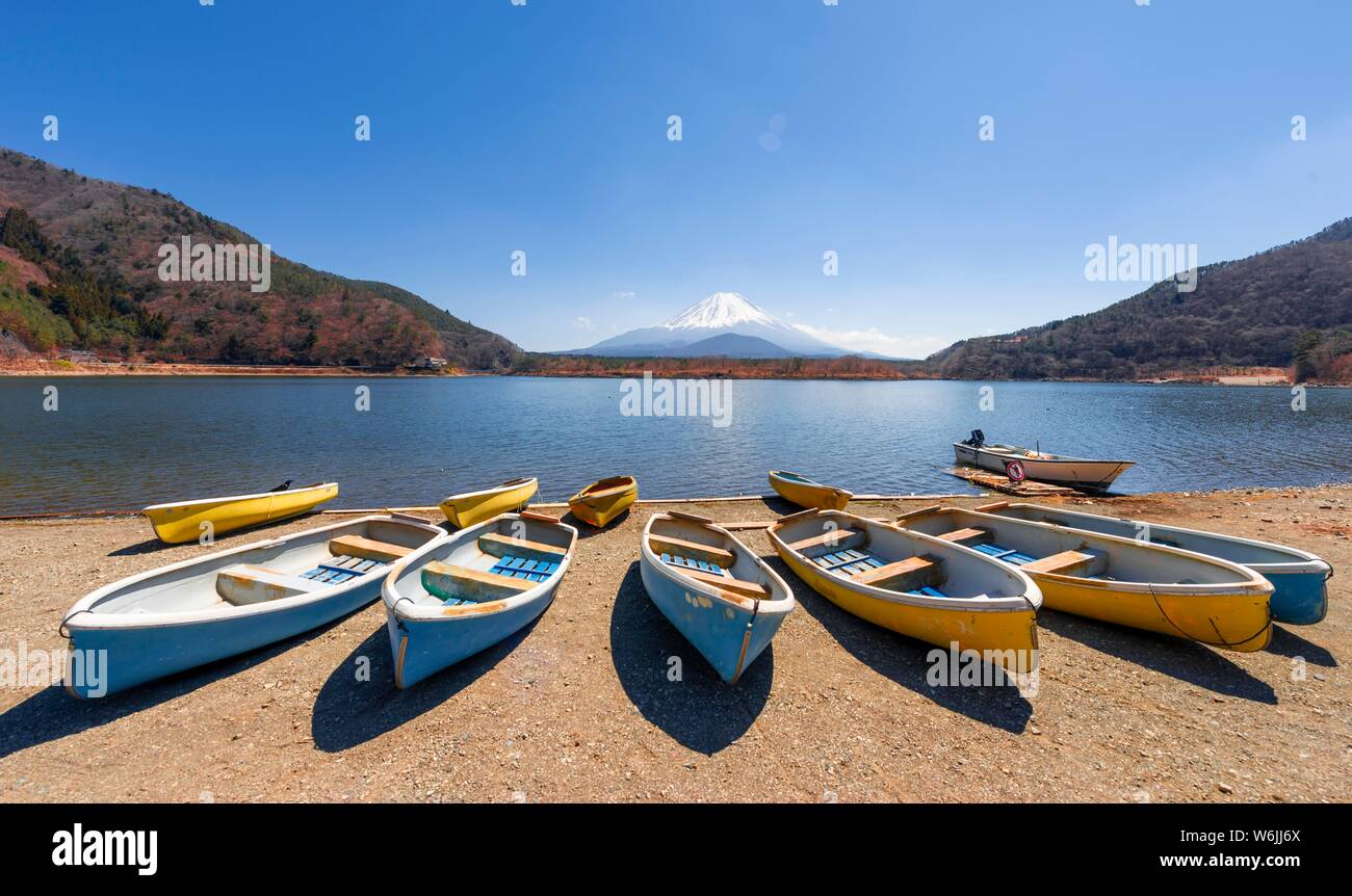 Ruderboote am Ufer, Blick über den See auf den Vulkan Mt. Fuji, Motosu See, Yamanashi Präfektur, Japan Stockfoto