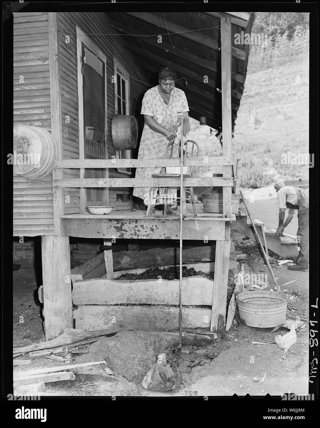 Frau Butler Phillips, Ehefrau von Bergmann, ein Huhn auf der Rückseite proch von ihrem Haus in Unternehmen. Adams, Rowe & Norman Inc., Porter Mine, Adamsville, Jefferson County, Alabama. Stockfoto