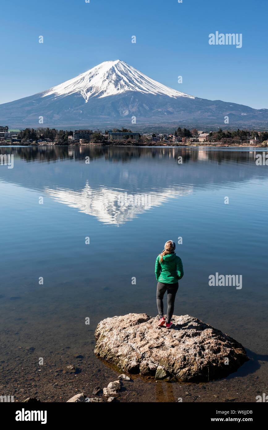 Junge Frau stehen auf Stein im Wasser, Lake Kawaguchi, zurück Vulkan Mt. Fuji, Yamanashi Präfektur, Japan Stockfoto