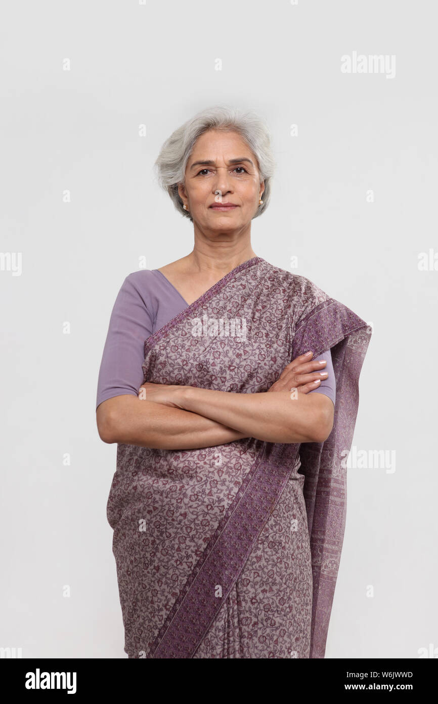 Porträt einer alten Frau, die mit gekreuzten Armen steht Stockfoto