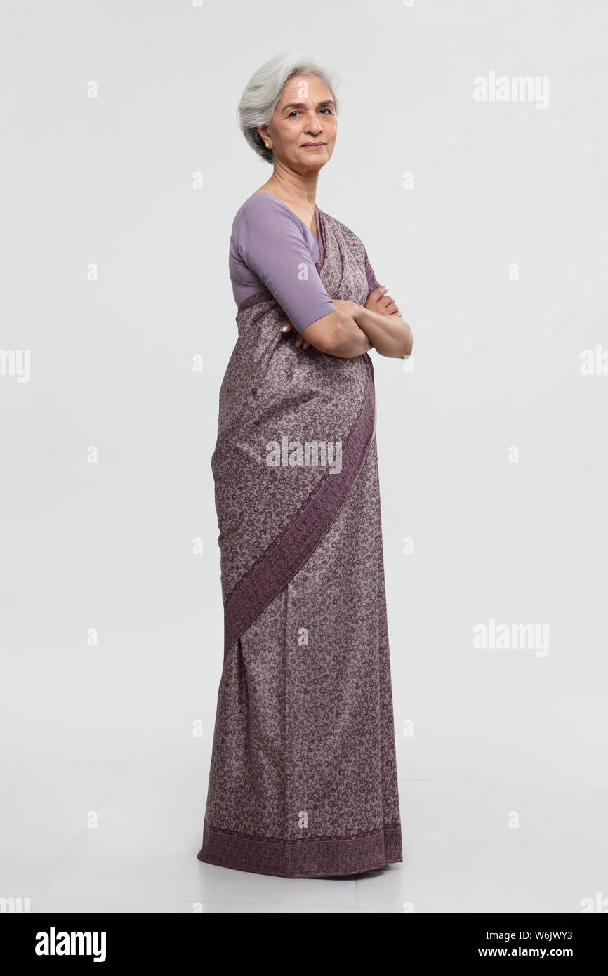 Porträt einer alten Frau, die mit gekreuzten Armen steht Stockfoto