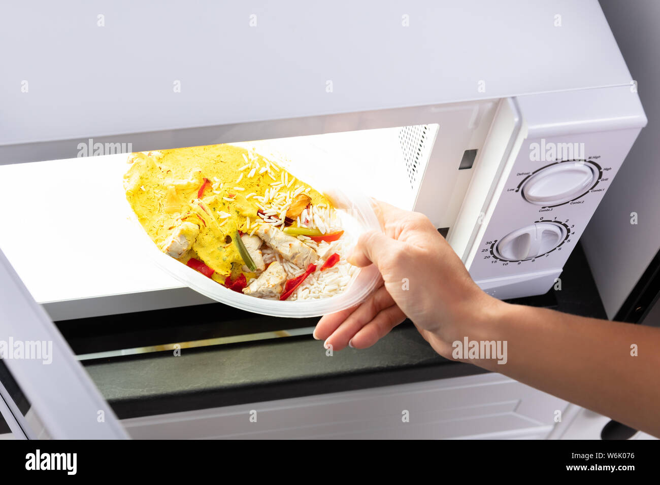 Nahaufnahme einer Person Heizung Essen in Mikrowelle Stockfoto