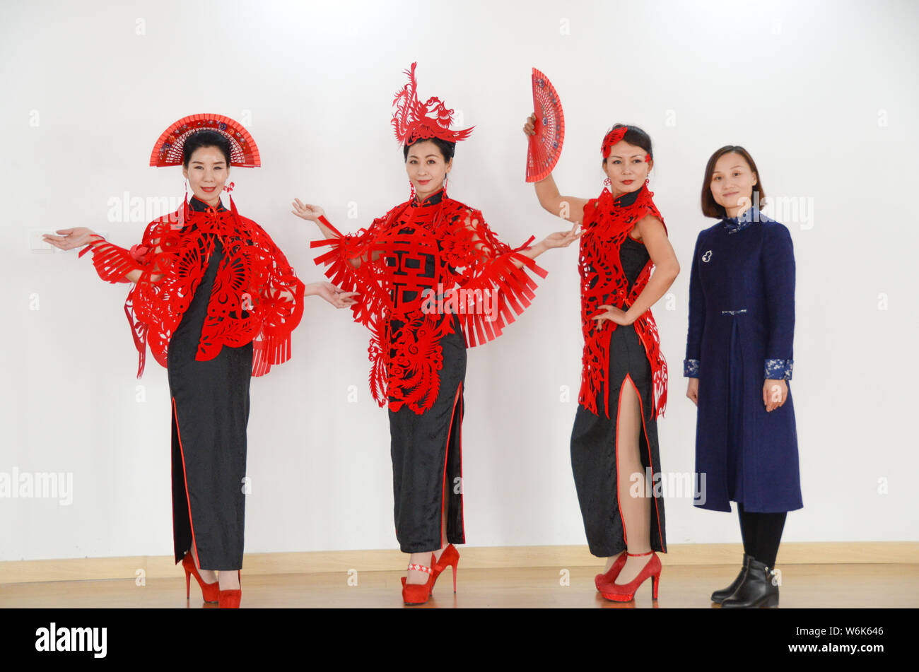 36-jährige Chinesische Handwerker Liang Ying, rechts, ein Erbe der Papier-Stecklinge, Posen für Fotos mit Modelle tragen Kopf Zubehör, Capes, und Ohr Stockfoto