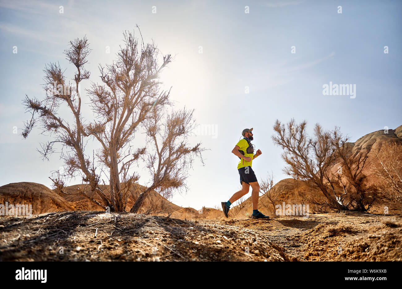 Runner Athlet mit Bart, der auf der freien Wildbahn Trail am roten Berge in der Wüste Stockfoto
