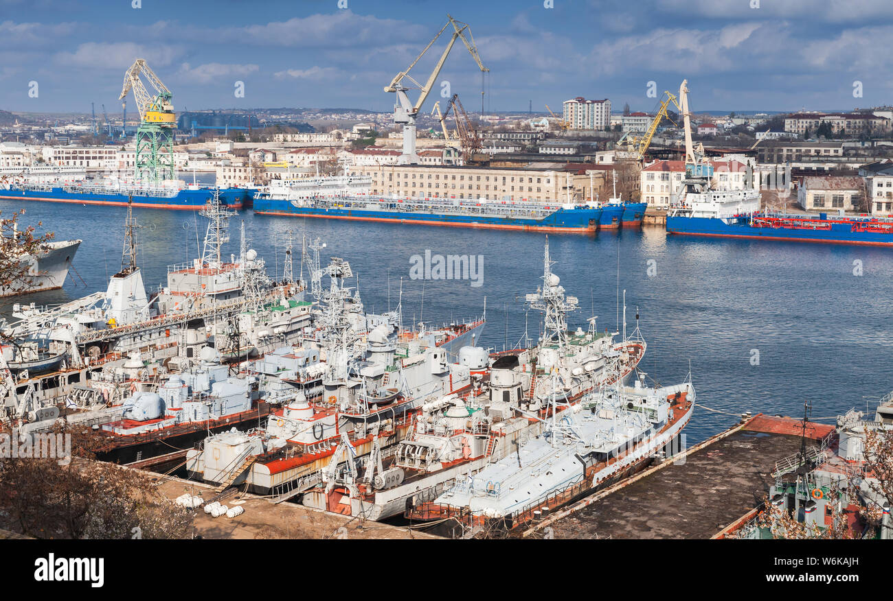Frachtschiffe und Russische Marine Kriegsschiffe in Yuzhnaya Bay, einer der Hafen Buchten in Sewastopol, Krim Stockfoto