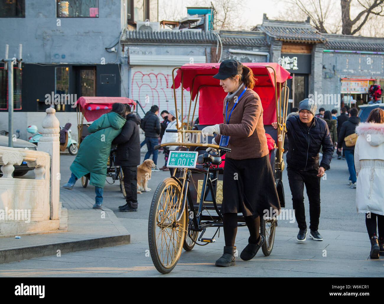 Chinesin Li Geyin, Mitglied der traditionell von Männern nur Dreirad fahren Team Houhai Baye, die Touren im Herzen von Peking führt, drückt Ihr t Stockfoto