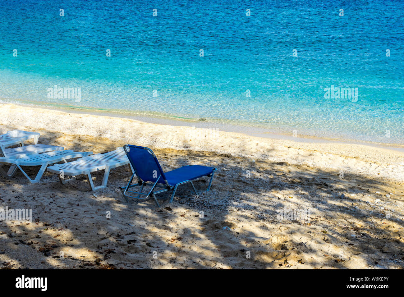Perfekte azurblauen Wasser am White Sand Beach und Sonnenliegen bereit, in den Schatten zu verwenden Stockfoto