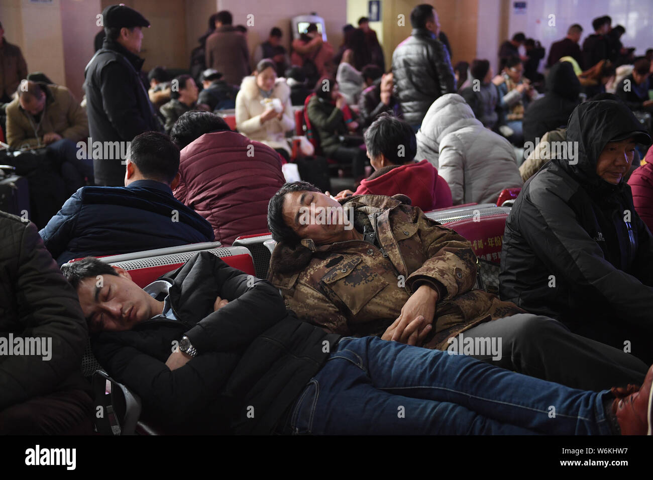 Passagiere Rest, wie sie an einem Busbahnhof aufgrund von Verspätungen und Annullierungen von schweren Schneestürmen in Hefei Stadt warten, East China Anh Stockfoto