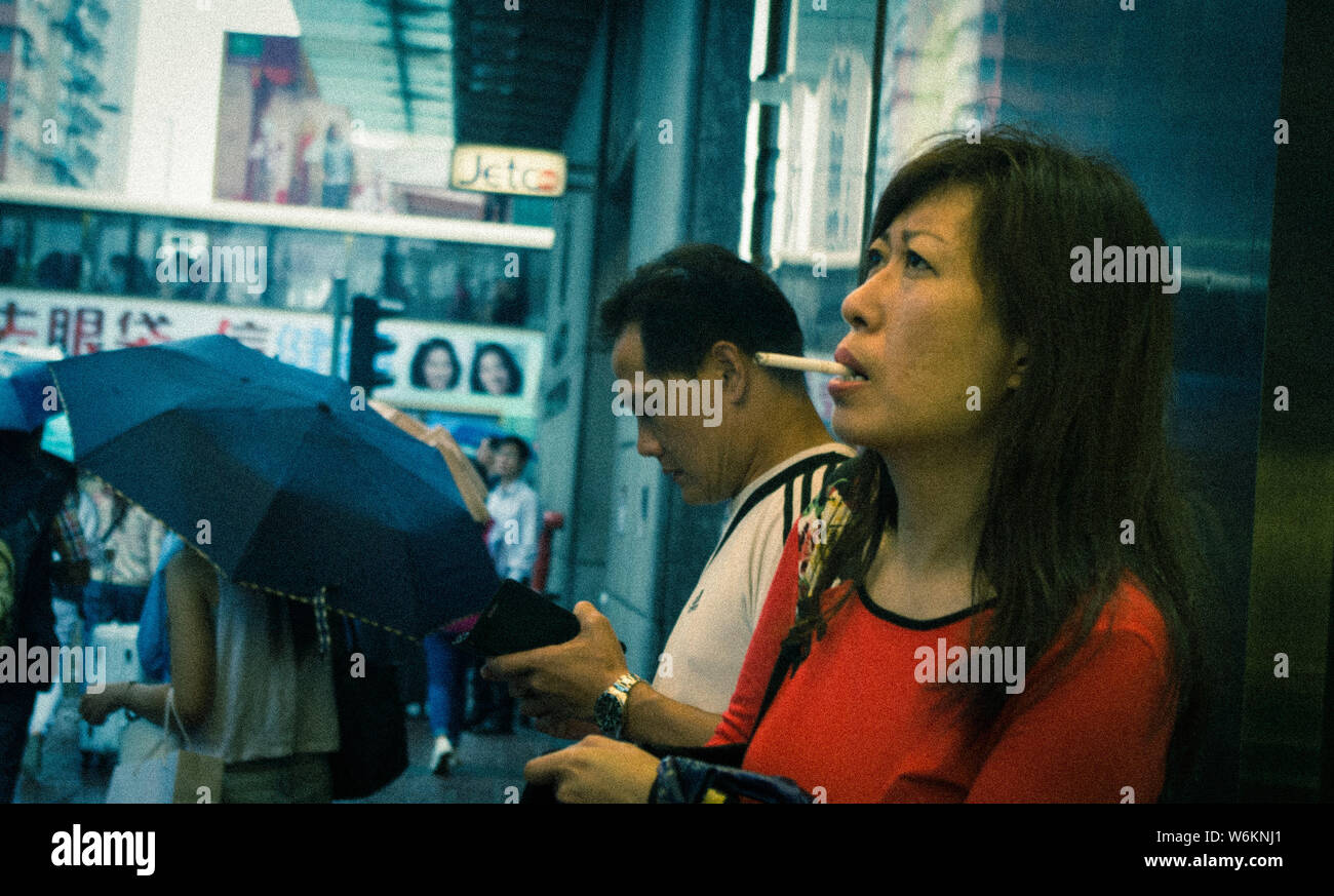 ---- Eine Frau raucht eine Zigarette auf einer Straße in Hongkong, China, 20. Mai 2016. Ein Bericht wurde festgestellt, dass China die am schnellsten wachsende Tabak werden Stockfoto