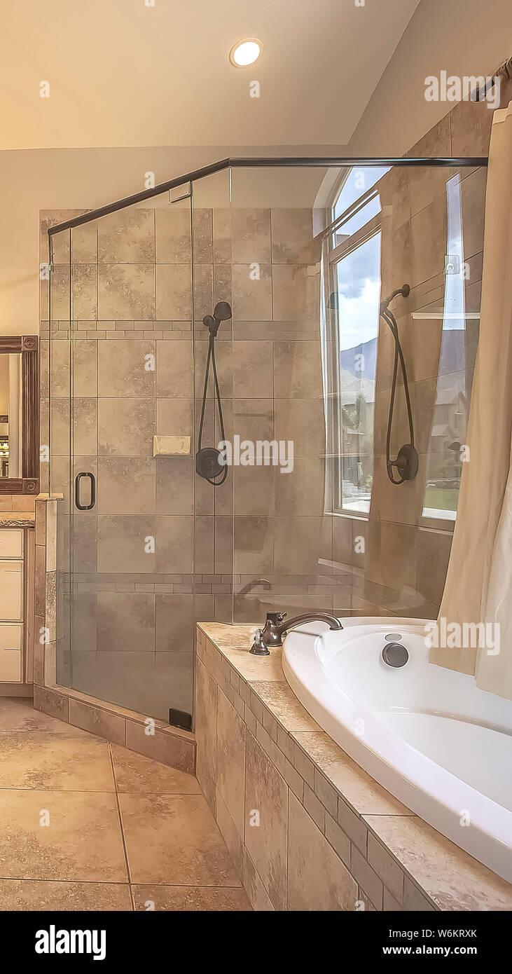 Vertikale rahmen Dusche neben einem ovalen Badewanne vor einem gewölbten  Fenster mit Vorhang Abschaltdruck Stockfotografie - Alamy