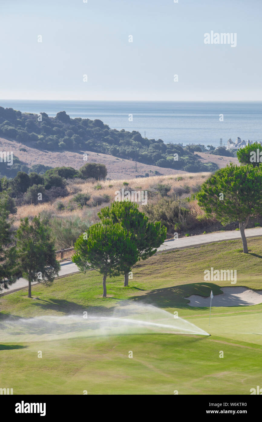 Sprinkler Bewässerungsanlage Arbeiten am grünen Golfkurs. Costa del Sol, Malaga, Spanien Stockfoto