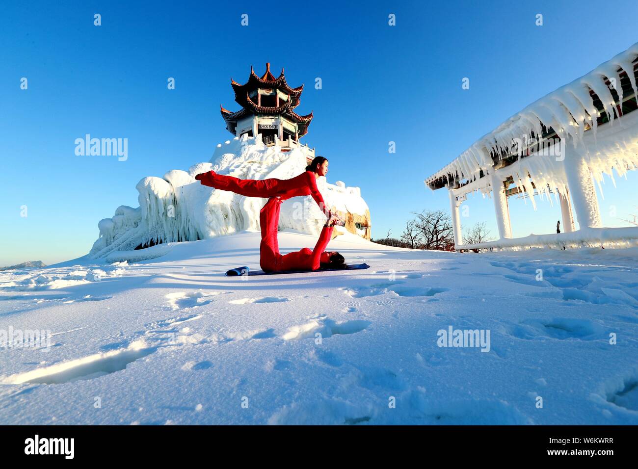 Chinesische Mädchen das Tragen der roten Yoga Kleidung yoga führen Sie vor Kälte an einem Ski Park in Luanchuan County, Luoyang City, Central China Provinz Henan, 11 J Stockfoto