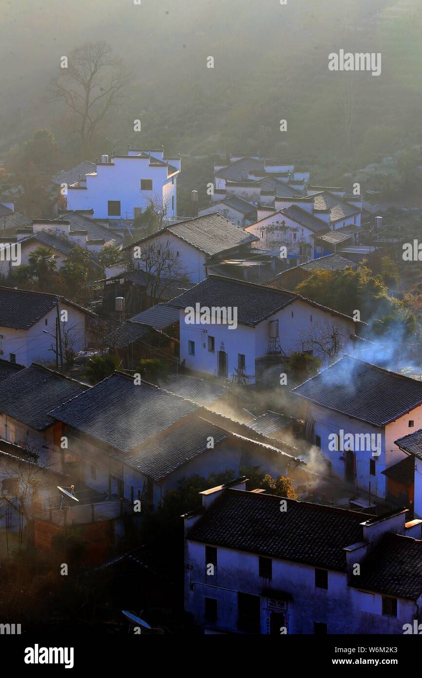 Winterlandschaft von alten Häusern mit Mau Tou Wand (Pferdekopf an der Wand) mit Rauch von Küche, Schornsteine in Wuyuan County, Stadt Shangrao, East China Ji Stockfoto