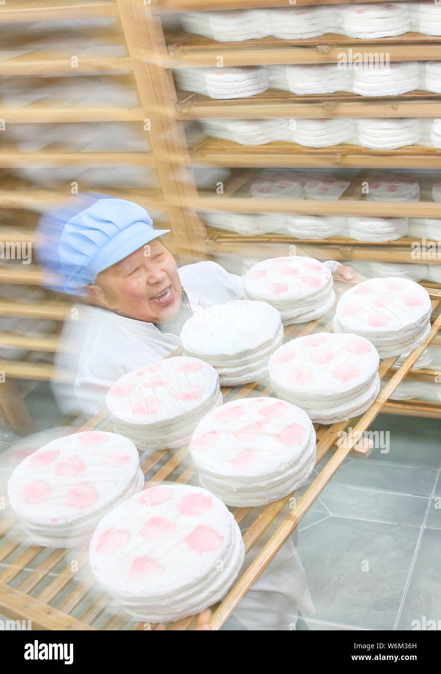 Eine chinesische Konditor trägt Linzi gedämpftem Reis Kuchen in einer Bäckerei in Rugao Stadt, der ostchinesischen Provinz Jiangsu, 30. Januar 2018. Konditoren gemacht Stockfoto