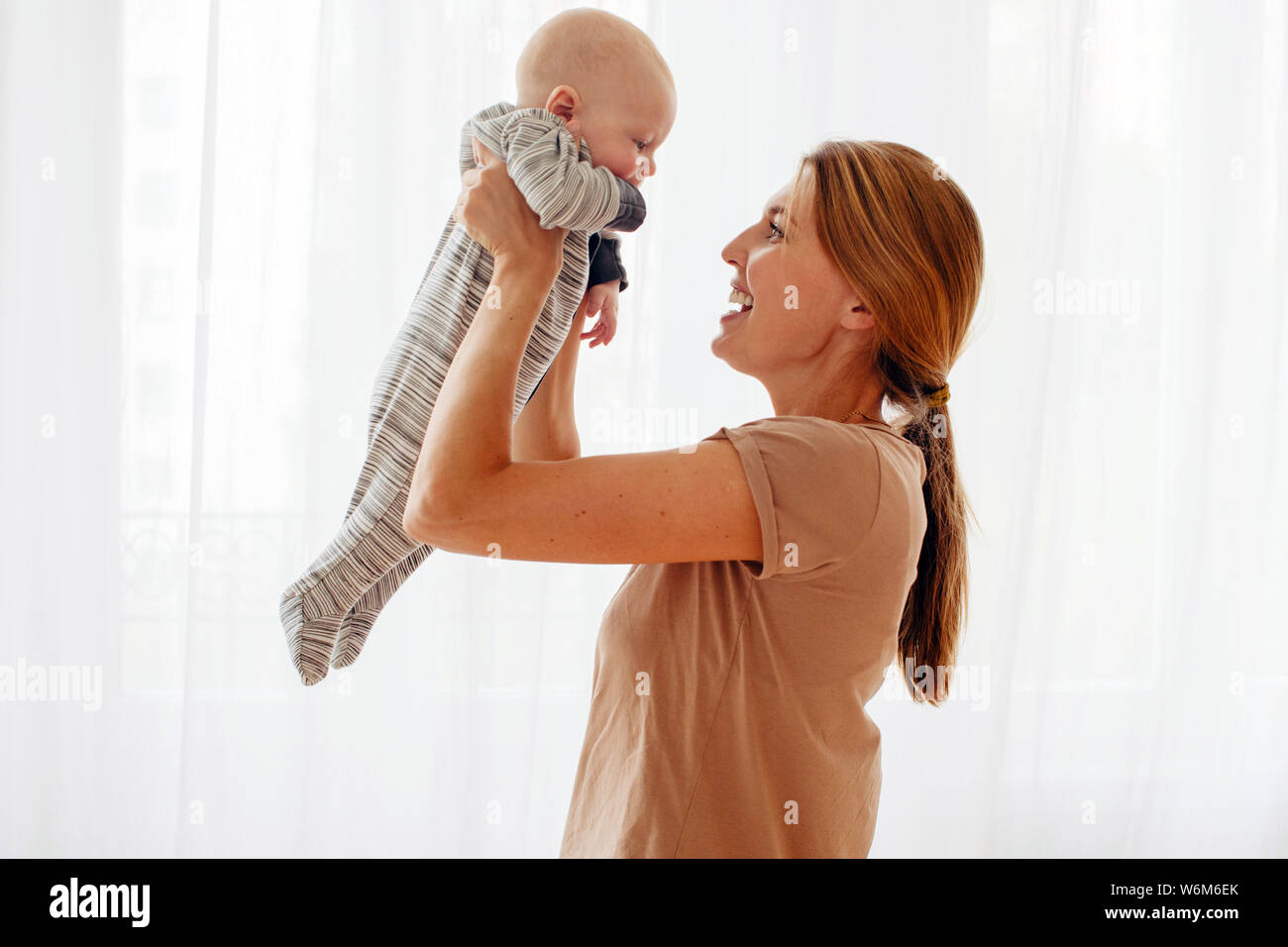 Glückliche Familie Mutter spielt mit neugeborenen Babys Stockfoto