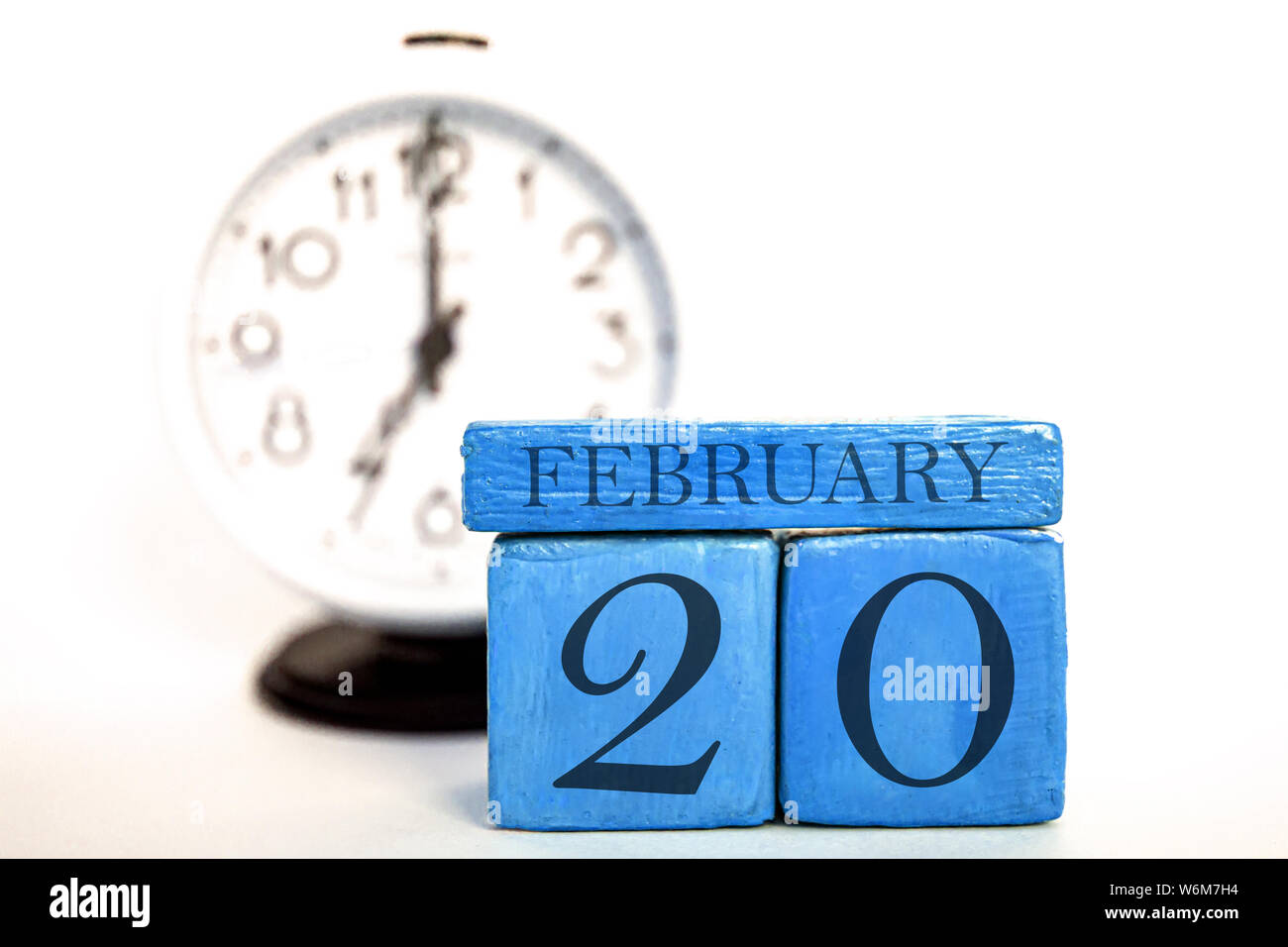 Februar 20th. 20. Tag des Monats, handgefertigten Holz Würfel Kalender und Wecker auf Blau. Winter Monat, Tag des Jahres Konzept. Stockfoto