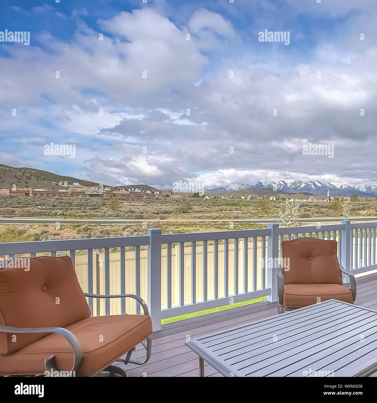 Platz Sitzecke auf einem Home Deck mit Blick auf die Straße Häuser Berg und bewölkter Himmel Stockfoto