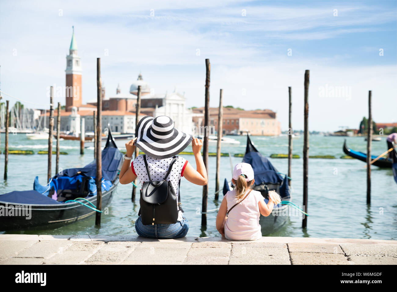 Mutter und Tochter sitzen Vor der Gondeln auf der Suche nach San Giorgio Maggiore Stockfoto