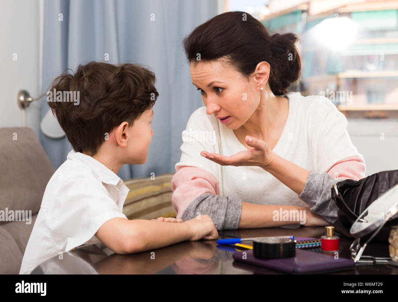 Verärgert Mutter diskutieren Fehlverhalten mit Tween Sohn, während Sie zu Hause sitzen Stockfoto