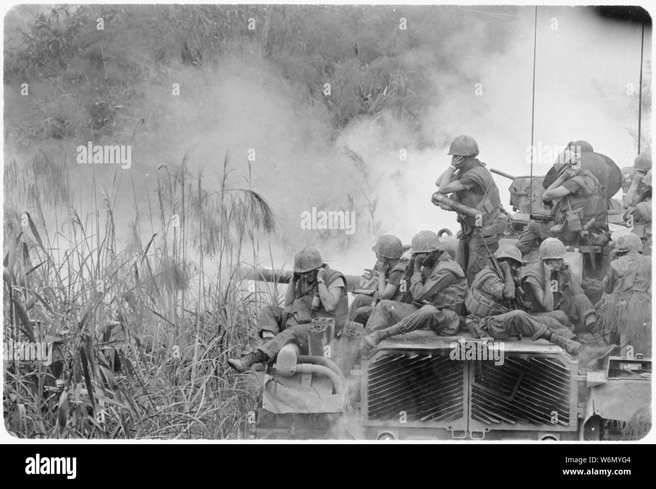 Vietnam.... Marines reiten auf einem M-48 tank Abdeckung ihre Ohren als te 90-mm-Kanone Brände während einer Straße Schleife südwestlich von Phu Bai. Stockfoto