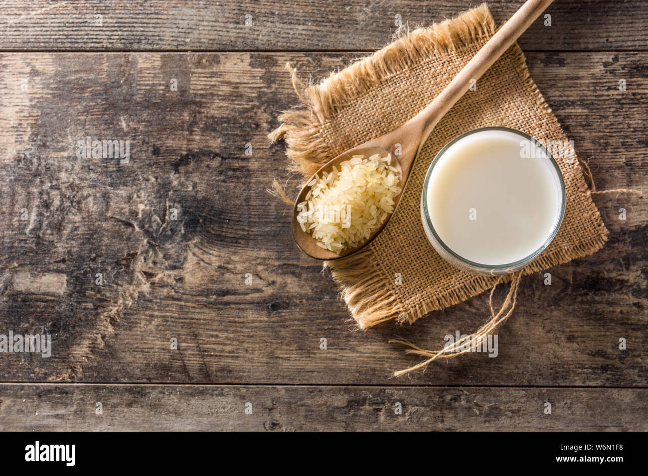 Reis Milch in Glas auf hölzernen Tisch. Ansicht von oben. Copyspace Stockfoto
