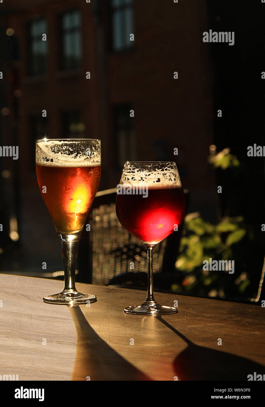 Zwei Gläser mit kaltem Bier und Apfelwein auf hölzernen cafe Tabelle. Dunkel Unschärfe Hintergrund mit Kopie Raum Stockfoto