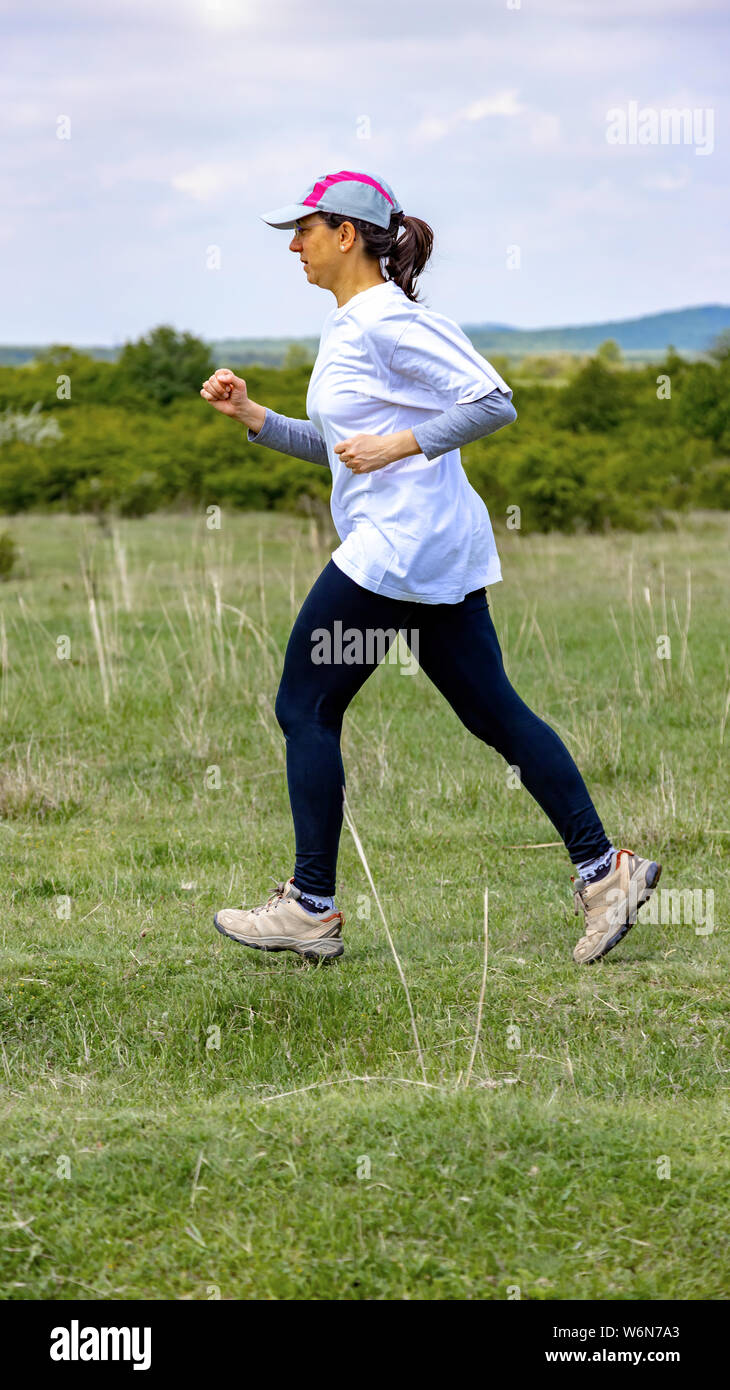 Spanische Frau läuft auf Wiese Stockfoto