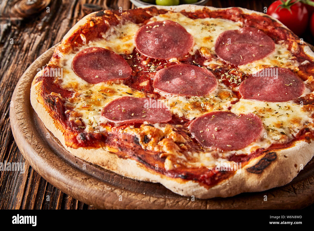 In der Nähe auf einer Flamme gegrillte knusprige italienische Pizza mit Tomaten, Mozzarella in Scheiben geschnitten und würzige Salami Wurst Stockfoto