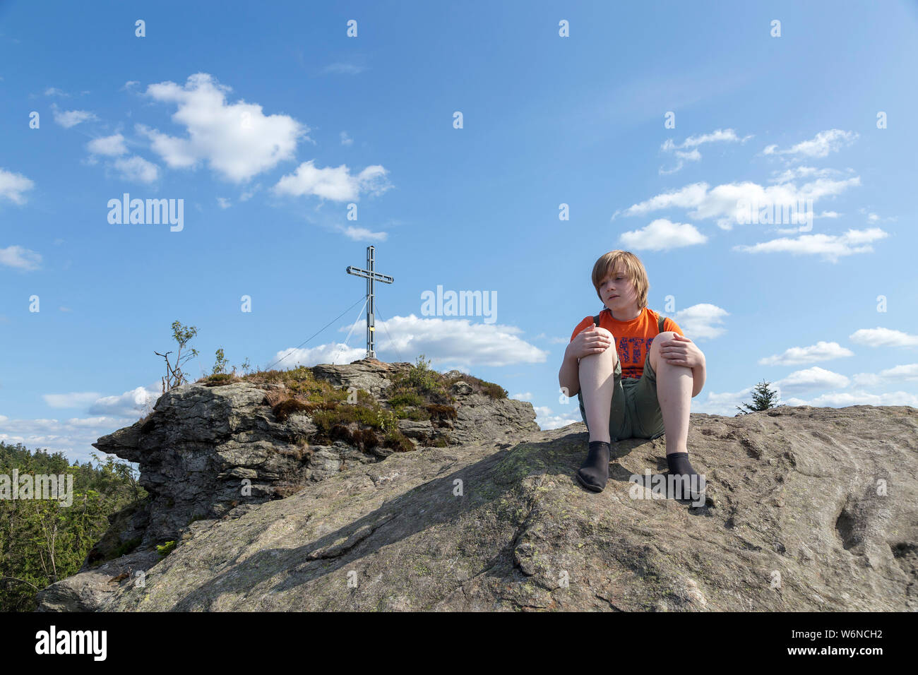 Junge mit minimalistische Schuhe sitzen auf dem Gipfel des Rauchröhren (Rauch Rohre), Eck, Bayerischer Wald, Bayern, Deutschland Stockfoto