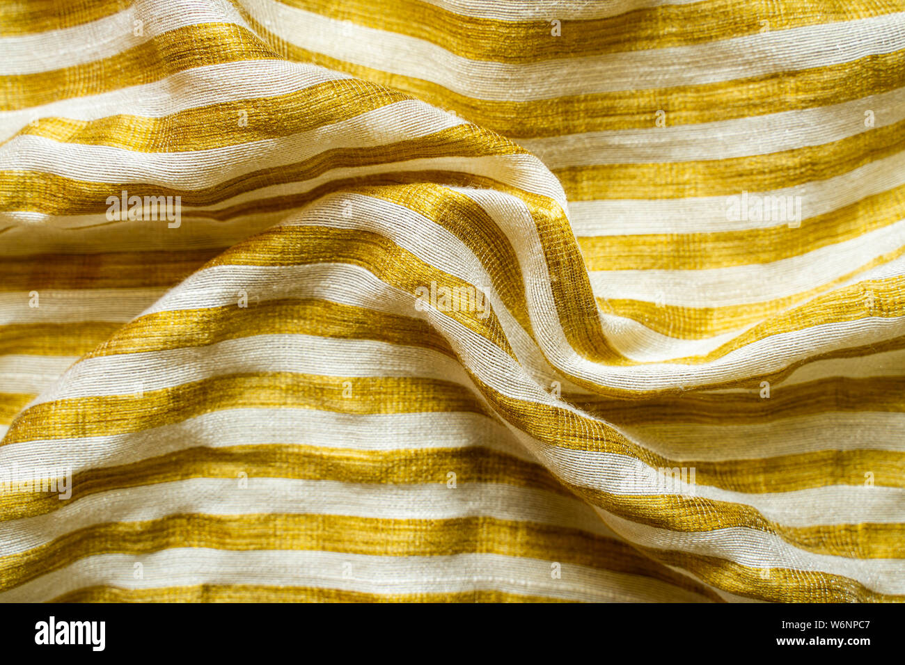 Gelb-weiß gestreiften Stoff Hintergrund. Gold Metallic Garn gestreifte Maschenware Stockfoto