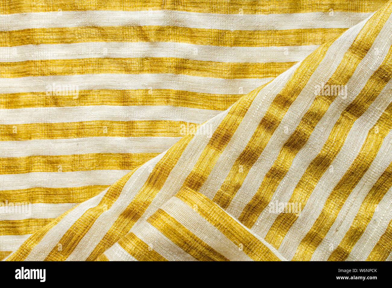 Gelb-weiß gestreiften Stoff Hintergrund. Gold Metallic Garn gestreifte Maschenware Stockfoto