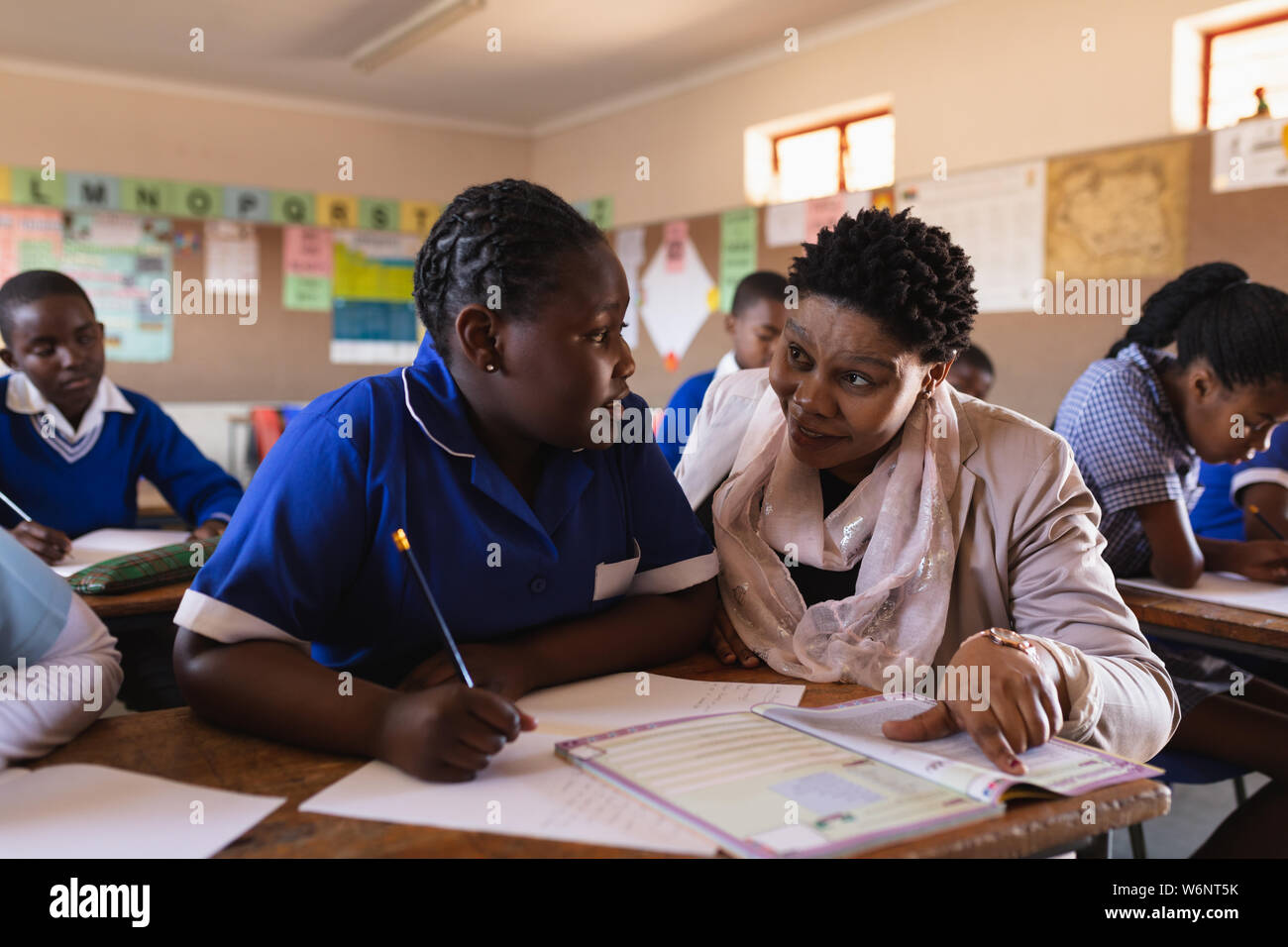 Lehrer Schüler helfen in eine Lektion an einem Township School Stockfoto