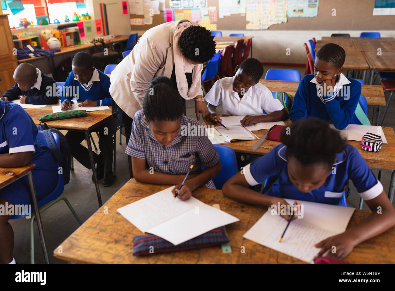 Lehrer Schüler helfen in eine Lektion an einem Township School Stockfoto