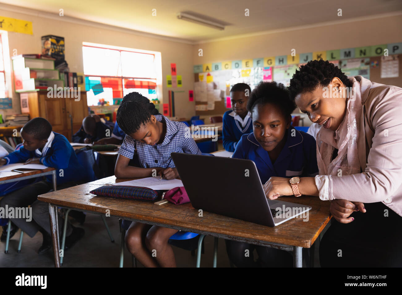 Lehrer Schüler helfen in eine Lektion an einem Township School Stockfoto
