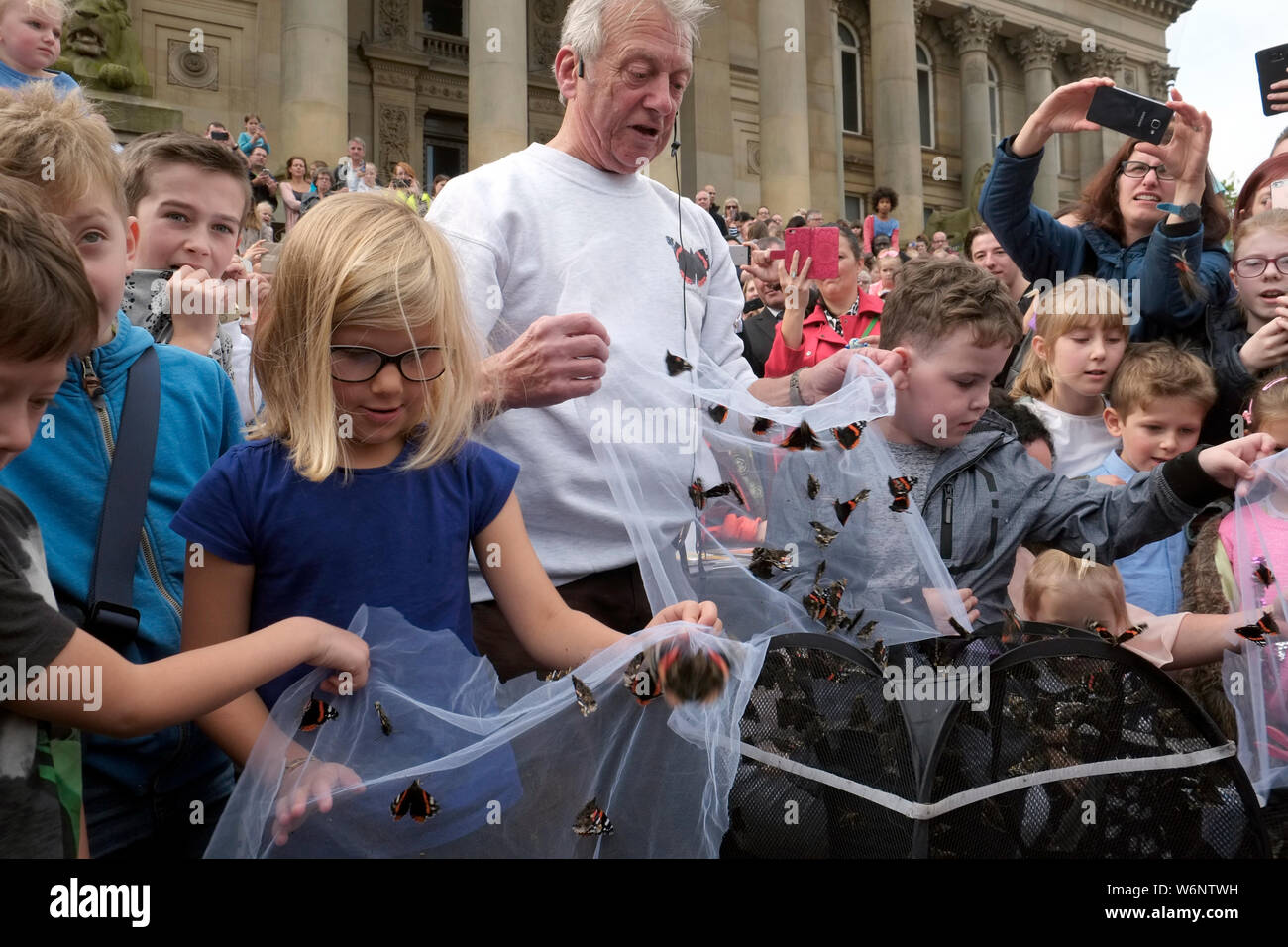 Schmetterling Experte Ray Sandiford und Kinder rote Admiral Schmetterlinge auf Bolton Rathaus Schritte Großbritannien einen Butterfly Conservation Awareness Event. Stockfoto