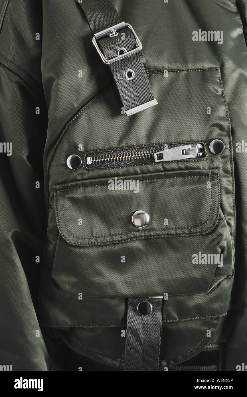 Teil einer Olive modische Jacke mit verschiedenen Taschen, Reißverschluss, Gürtel und Tasten. Nahaufnahme einer bequeme Kleidung. Beispiel der Hardware. Stockfoto